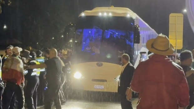 Los manifestantes rodean el autobús del equipo de fútbol femenino iraní cuando sale del estadio de Gold Coast.