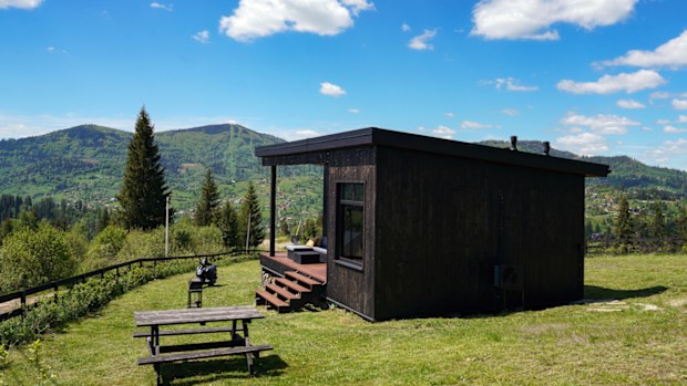 Black wooden cabin with mountain view