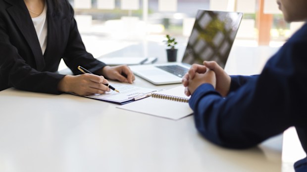 The manager is reading the resume and is interviewing the new employee. Negotiating business and signing a contract. Lawyer and legal advisor.