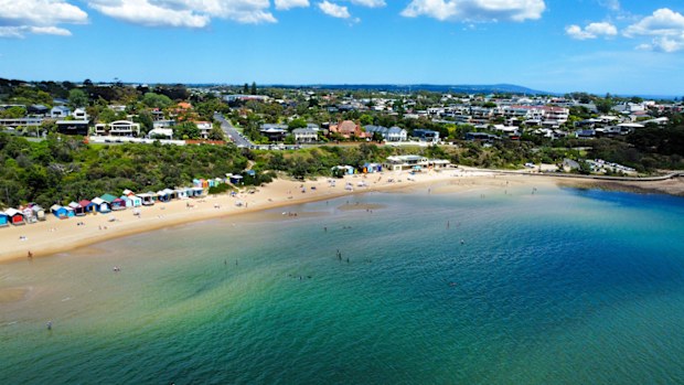 The bathing or beach boxes at mills beach in Mornington on the beautiful Mornington peninsula coast. Stunning Australian coastline in Victoria. Aerial Drone photograph shot with a dji mini2. People swimming and enjoying the beach in Summer. Calm water.