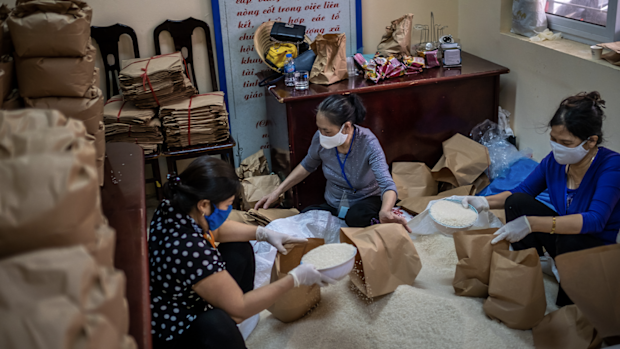 HANOI, VIETNAM - APRIL 17: Volunteers wear face masks amid concerns of the spread of the coronavirus disease (COVID-19) while preparing free rice bags on April 17, 2020 in Hanoi, Vietnam. Several self-catering "rice ATMs, or rice dispensers, have been launched providing free rice to low-income earners to survive the pandemic. 