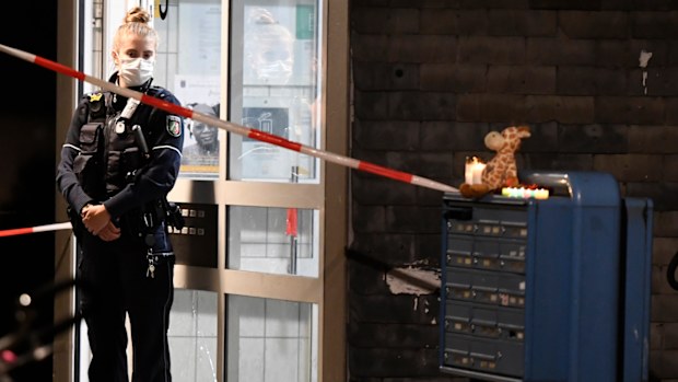 A policewoman stands in front of a house entrance, Thursday, Sept. 3, 2020, in Solingen, Germany. 
