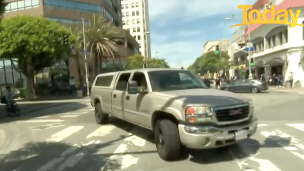 A large SUV drives by as the explosion rings out.