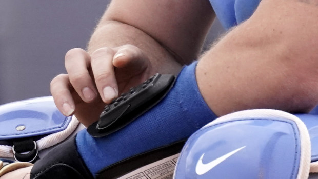 Kansas City Royals catcher Cam Gallagher uses a wrist-worn device used to call pitches.