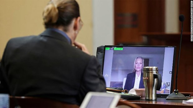 Johnny Depp listens as his former girlfriend, Kate Moss testifies.