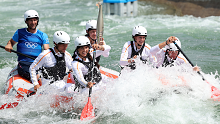 Australia's Jessica Fox helps carry the Olympic Torch down the canoe slalom course at Vaires-Sur-Marne Nautical Stadium.