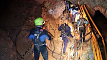 In this handout photo released by Thai Navy, Saturday, July 7, 2018, Thai rescue teams walk inside cave complex where 12 boys and their soccer coach went missing in Mae Sai, Chiang Rai province, northern Thailand. Chiang Rai Gov. Narongsak Osatanakorn says authorities are waiting for two big groups of volunteer divers to arrive later Saturday and Sunday, after which they'll be ready to begin the operation of bringing them out. (Thai Navy via AP)