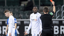Referee Frank Willenborg shows Moenchengladbach's Marcus Thuram the red card.