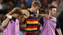 Adelaide Crows captain Rory Sloane is helped from the field injured.