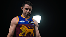 Lachie Neale of the Brisbane Lions looks on.