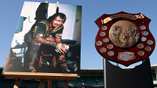 A photo by Tommy Raudonikis playing for Australia and the Winfield State of Origin trophy on display.