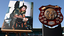 A photo by Tommy Raudonikis playing for Australia and the Winfield State of Origin trophy on display.