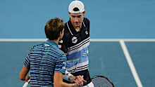 John Isner (R) shakes hands with Daniil Medvedev after their ATP Cup match.