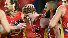 Matt Rowell is congratulated by Suns teammates after kicking a goal against West Coast.