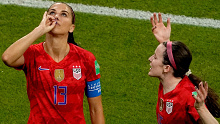 Alex Morgan (L) sips tea after her goal.