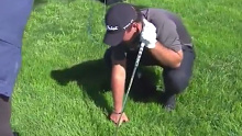 Patrick Reed pokes at the lie while making his embedded ball relief claim at Torrey Pines.