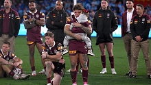 Reece Walsh looks dejected as he holds his daughter following the Maroons' loss in game three.