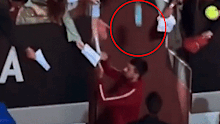 A bottle falls from the crowd while the star signs autographs.