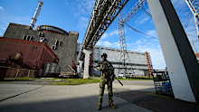 A Russian soldier guards the Zaporizhzhia nuclear power plant in Ukraine as a United Nations expert warned it is out of control.