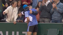 Alex De Minaur hugs a young fan after securing a spot in the fourth round at Roland-Garros with a win over Jan-Lennard Struff.