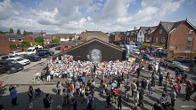 People look at the newly repaired mural of England footballer Marcus Rashford, covered in well wishes.