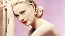 Grace Kelly (1929-1982), US actress, wearing an off-the-shoulder dress in a studio portrait, against a lilac background, circa 1955. (Photo by Silver Screen Collection/Getty Images)