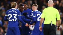 Noni Madueke, Nicolas Jackson and Cole Palmer of Chelsea argue over a penalty kick.