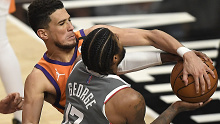 Devin Booker #1 of the Phoenix Suns fouls Paul George #13 of the LA Clippers.