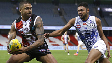 Bradley Hill of the Saints evades Tarryn Thomas of the Kangaroos.