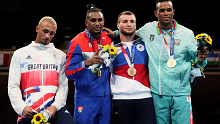 Benjamin Whittaker (L) glances down at his silver medal, while Arlen Lopez (2L) celebrates gold.