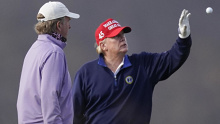 President Donald Trump catches a golf ball at Trump National Golf Club.