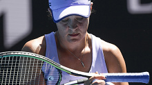 Ash Barty wipes the sweat from her racquet during her quarter-final match against Karolina Muchova.