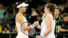 Ajla Tomljanovic and Jelena Ostapenko half-embrace at the net following their second round clash at the Australian Open.