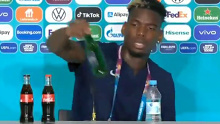 Paul Pogba removes a Heineken bottle during his press conference.