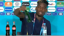 Paul Pogba removes a Heineken bottle during his press conference.
