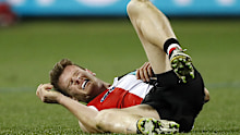 St Kilda's Darragh Joyce grimaces after being smashed by Geelong's Tom Hawkins.