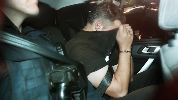 Fugitive Jonathan Dick is driven into Police Headquarters after his arrest in Melbourne.
