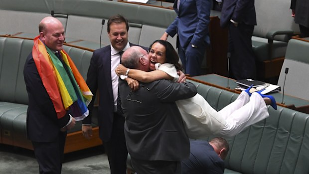 Liberal MP Warren Entsch lifts up Labor MP Linda Burney as they celebrate the passing of the Marriage Amendment Bill in the House of Representatives at Parliament House in Canberra, Thursday, December 7, 2017. 