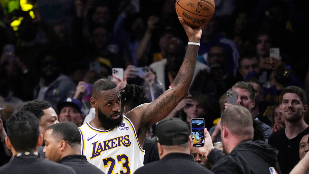 LeBron James acknowledges fans after becoming the first NBA player to reach 40,000 points in a career during the first half of the Lakers' match against the Nuggets.