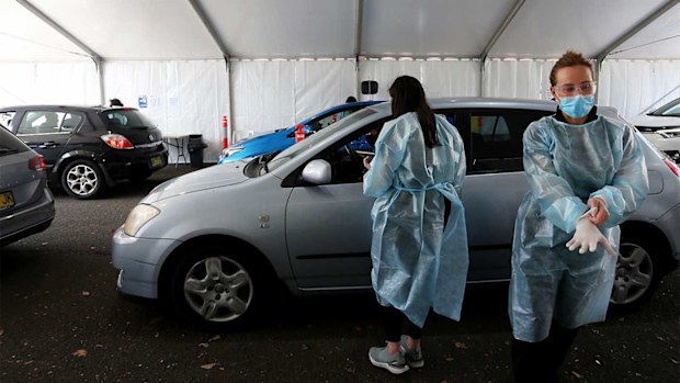 Healthcare workers consult with clients attending the Belmore Sports Ground vaccination hub in Sydney.