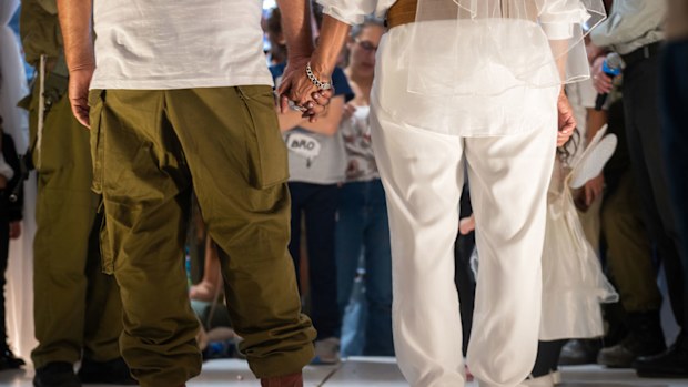 IDF officer Daniel (L), and his bride Kochava (R) stand under the 'chupa' as IDF Chief Cantor Lt. Col. Shai Abramson performs the ceremony.