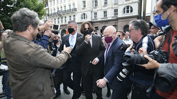 Actor Johnny Depp, centre, arrives at the High Court to give evidence in his libel case, in London, Wednesday July 15, 2020. 