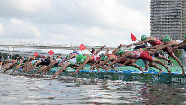 Triathletes jump into the water at the start of the swim