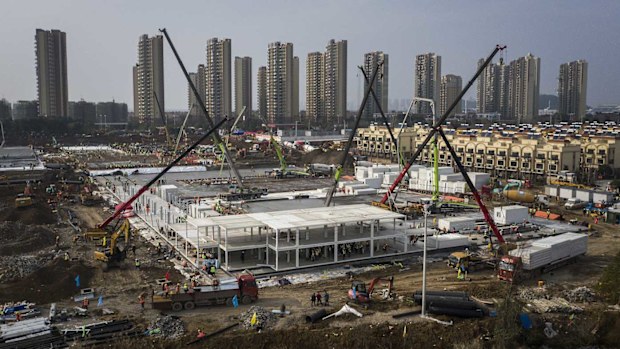 Hundreds of construction workers and heavy machinery build new hospitals to tackle the coronavirus on January 28, 2020 in Wuhan.