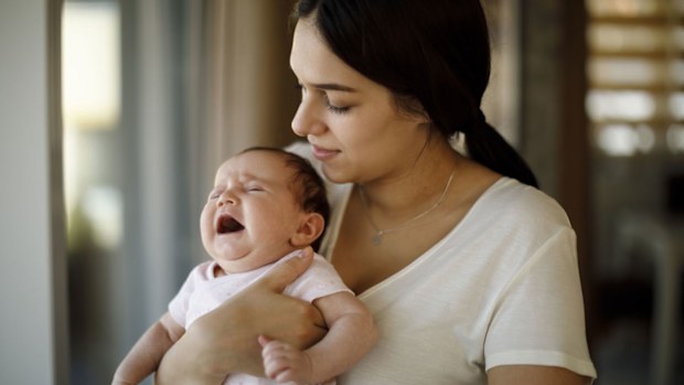 Newborn baby crying in mother hands