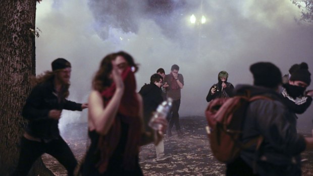 In Portland, police used tear gas and flash-bang grenades Friday to try to disperse the crowd after hundreds of people marched through the city. (AAP)