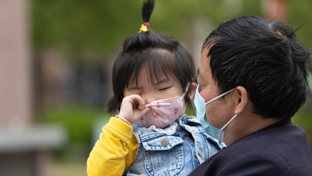 A man walks with his daughter at a residential area  on April 22, 2022 in Shanghai, China. 