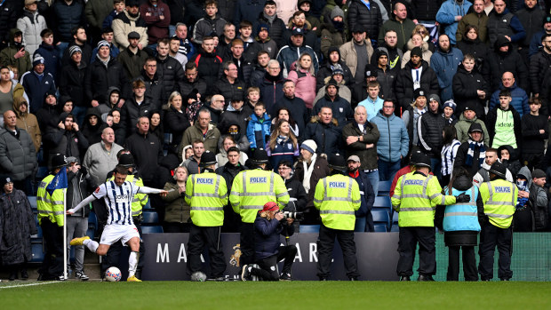 John Swift of West Bromwich Albion takes a corner-kick as local police officers stand to prevent a pitch invasion during the Emirates FA Cup Fourth Round match between West Bromwich Albion and Wolverhampton Wanderers at The Hawthorns on January 28, 2024 in West Bromwich, England. (Photo by Shaun Botterill/Getty Images)