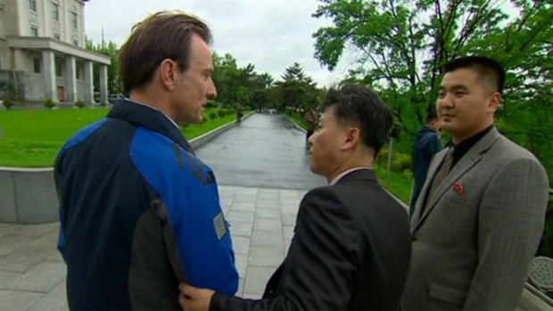 Rupert Wingfield-Hayes being led away from the entrance of Kim Il-sung University.