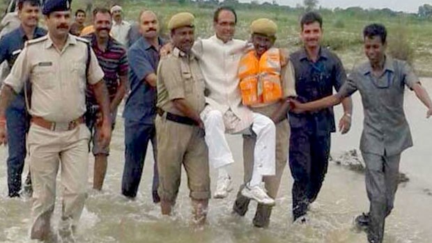 Indian politician Shivraj Singh Chouhan is carried through floods. (Supplied)
